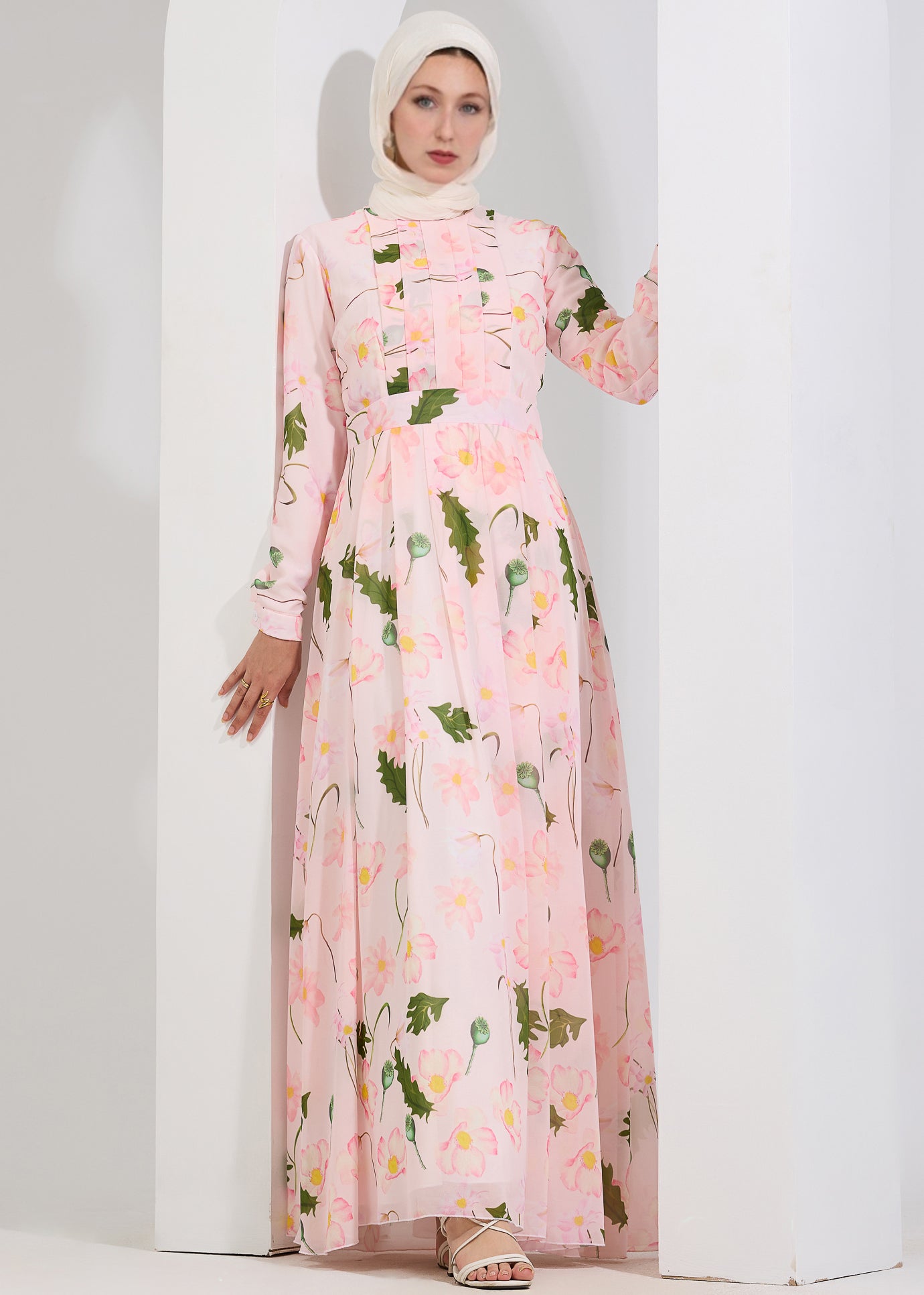 Model twirling in blush floral chiffon maxi dress