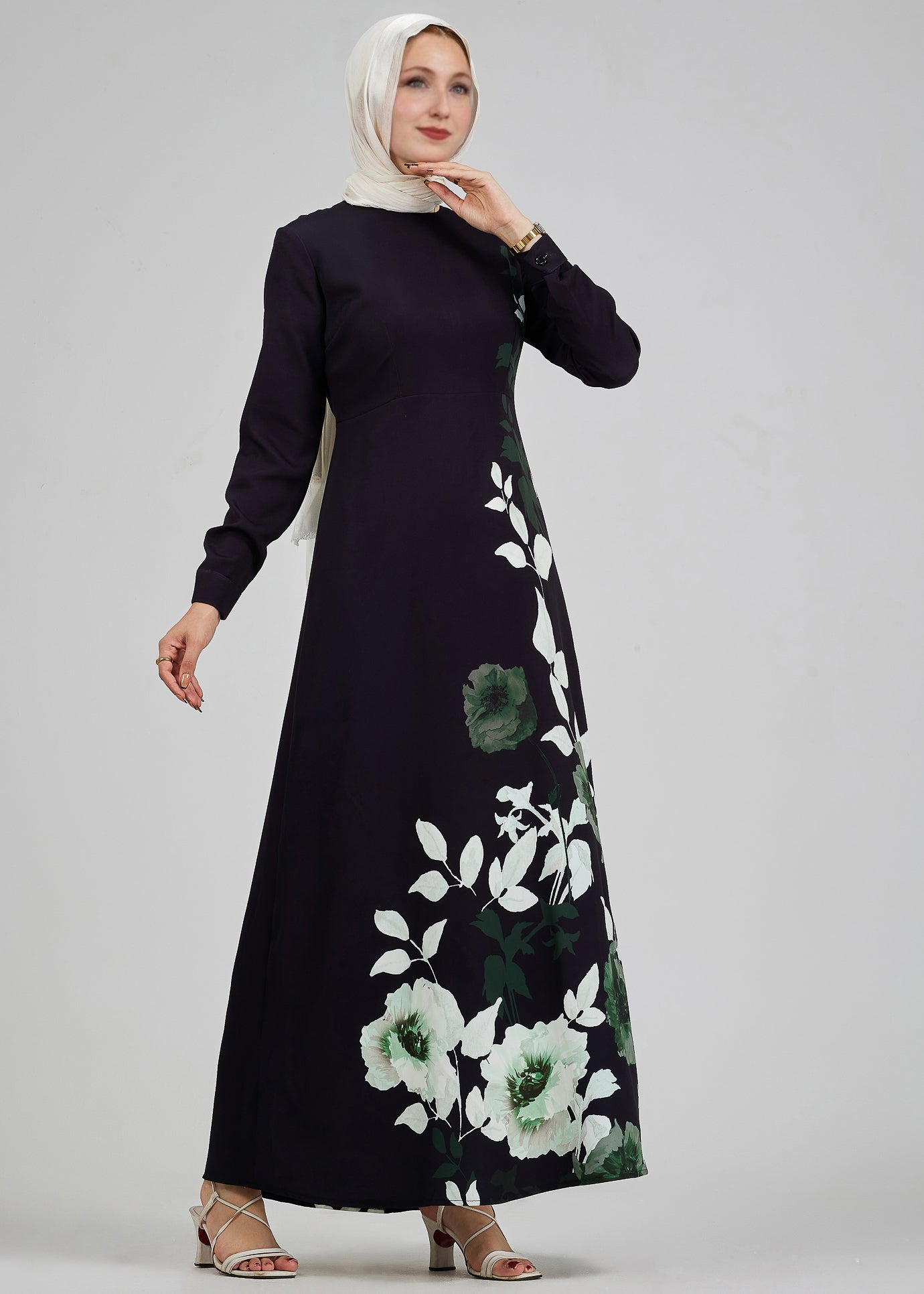 Elegant side profile of a woman in a black maxi dress featuring green and white floral patterns.