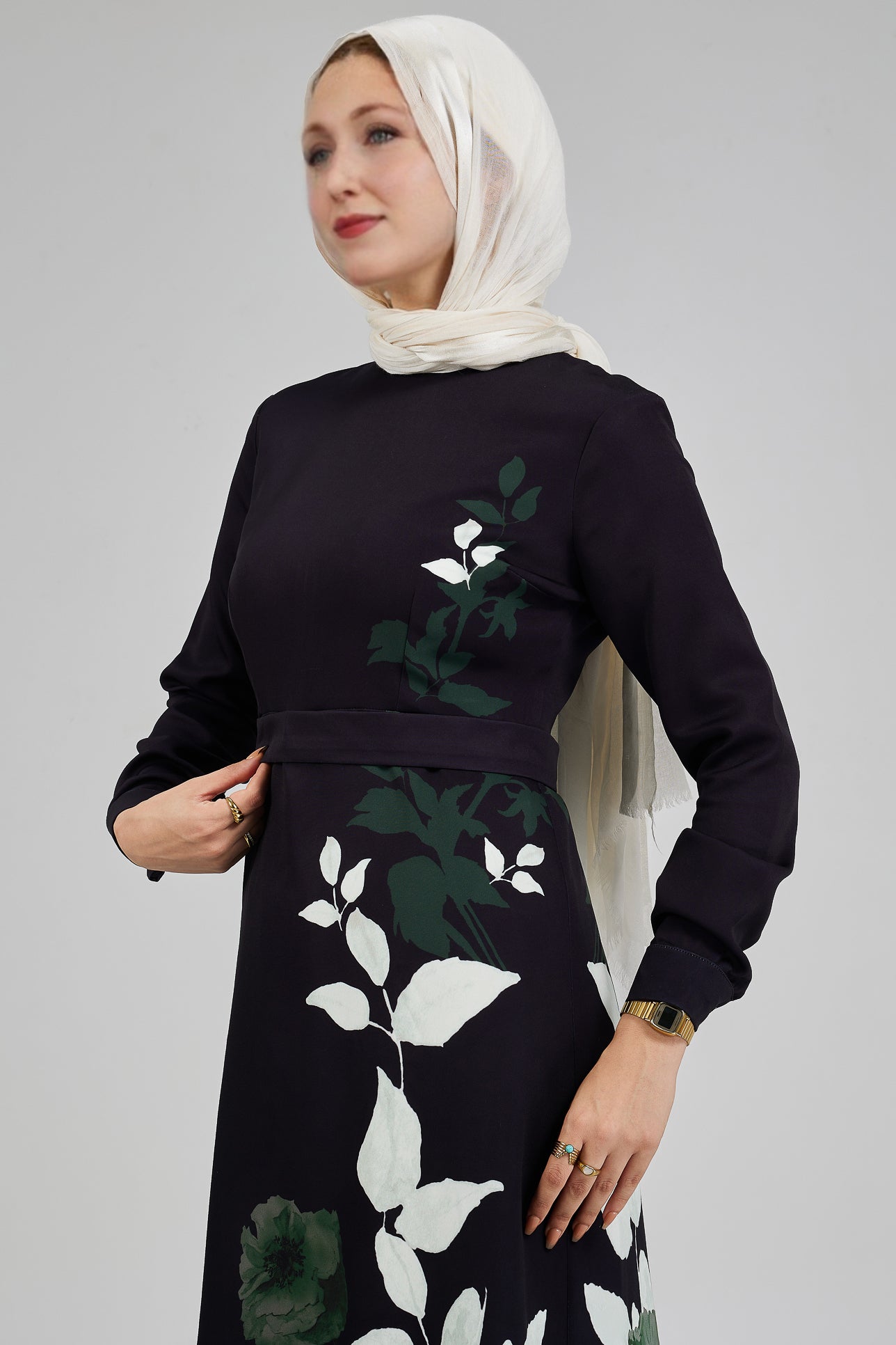 Full body front view of an elegant black floral maxi dress with green and white leaf patterns