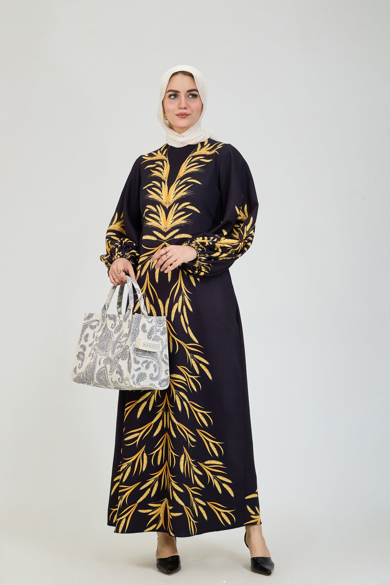  Back view of black crepe modesty dress with golden leaf pattern.