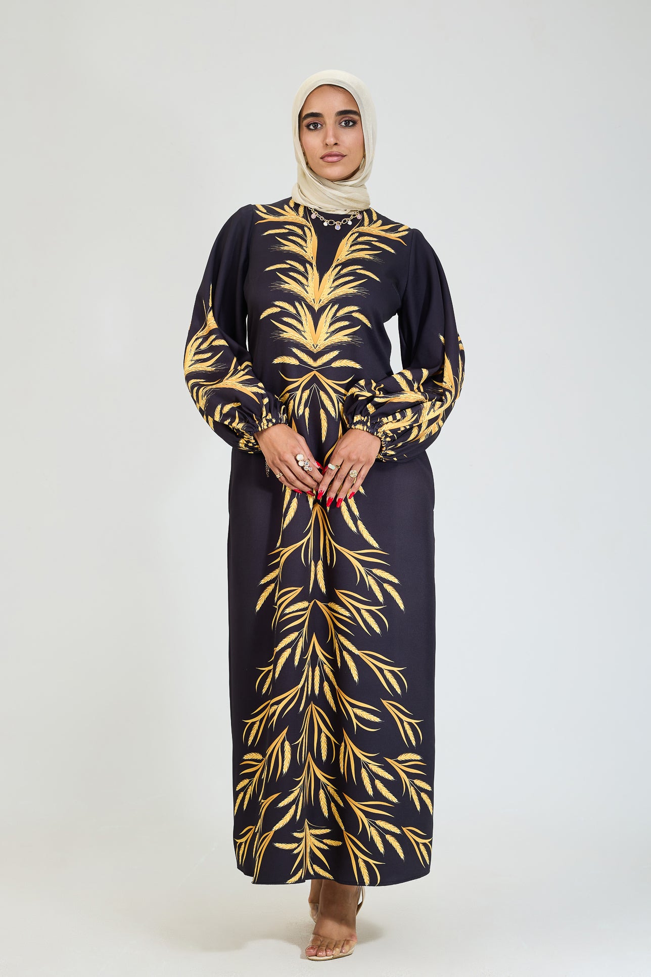 Side view of black crepe modesty dress with golden leaf details.
