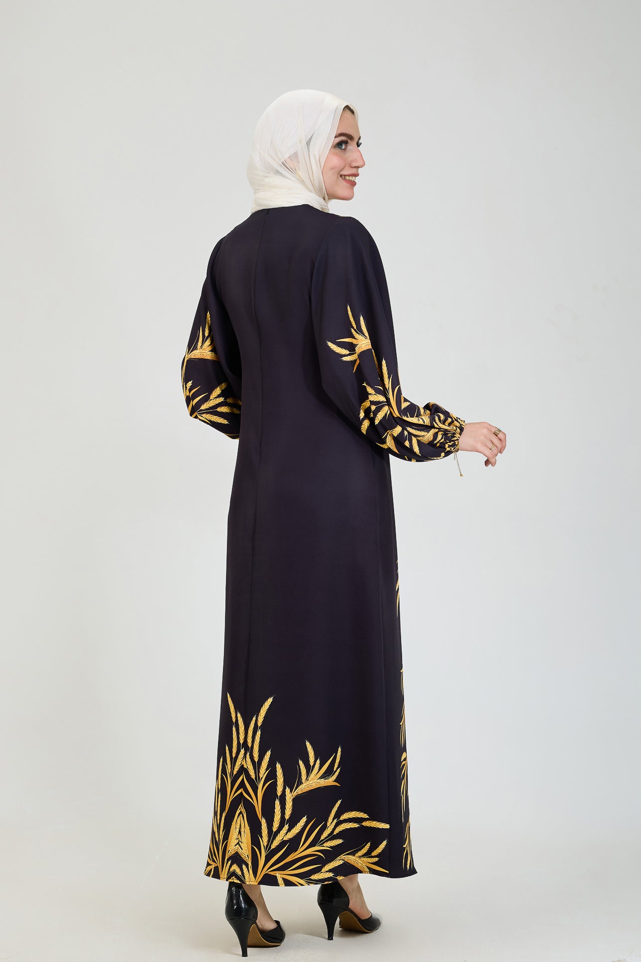 Side view of black crepe modesty dress with golden leaf details.