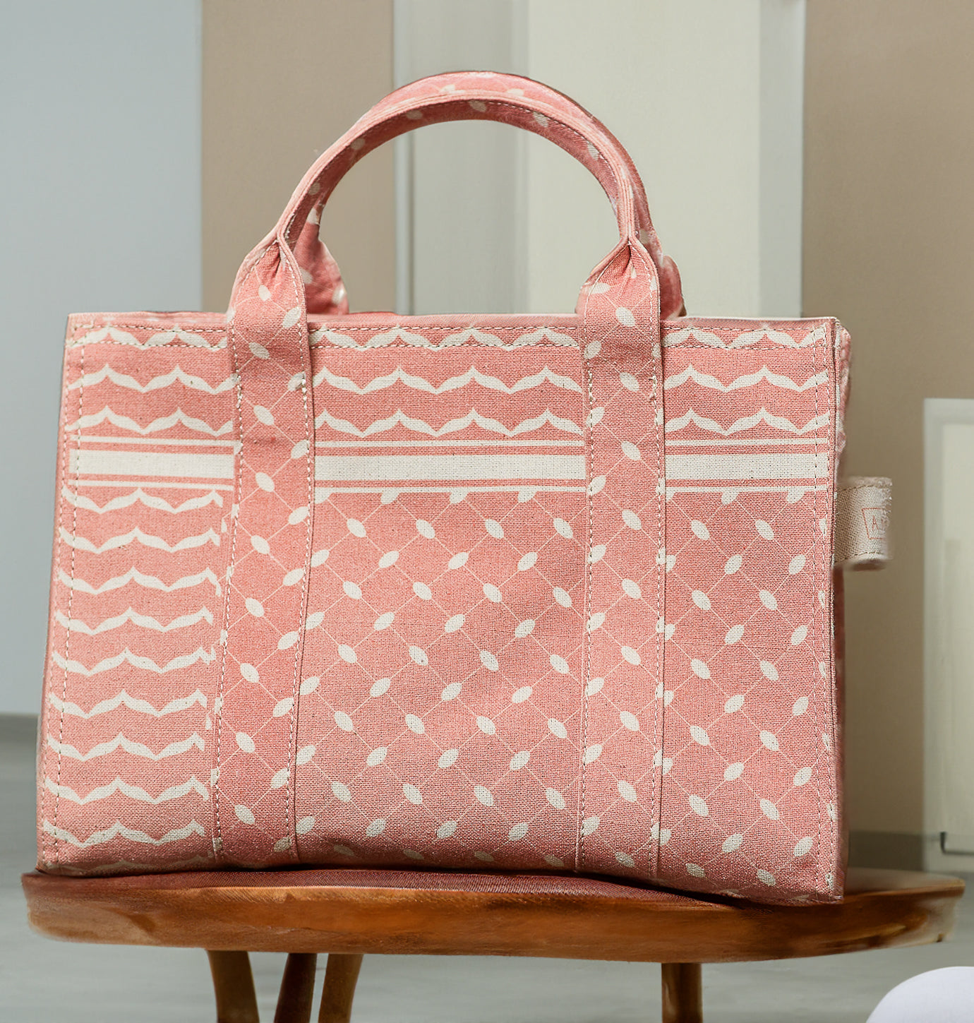 Close-up of the handle detail on the Heritage Coral and Cream Medium Tote