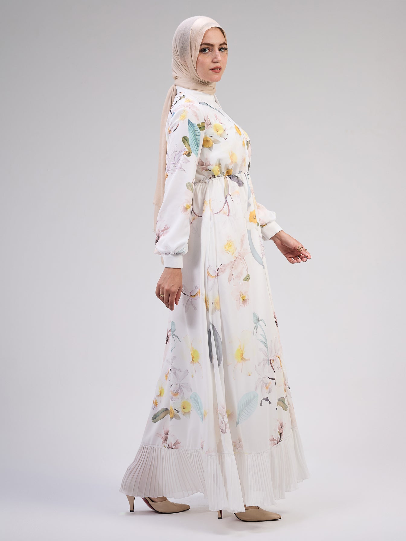 Close-up of the pleated hem on the ivory floral maxi dress