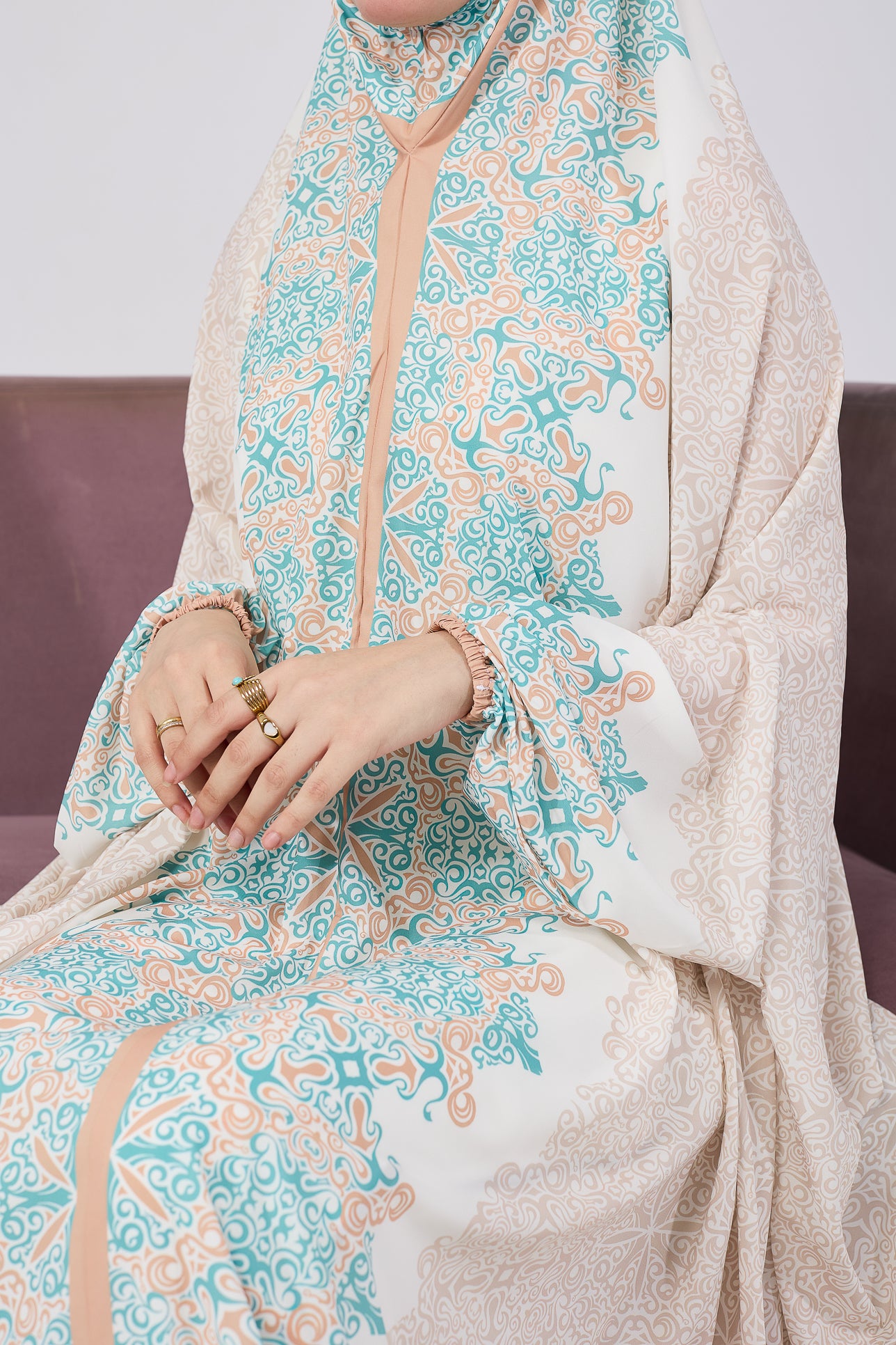 Sitting view of satin prayer gown with floral print
