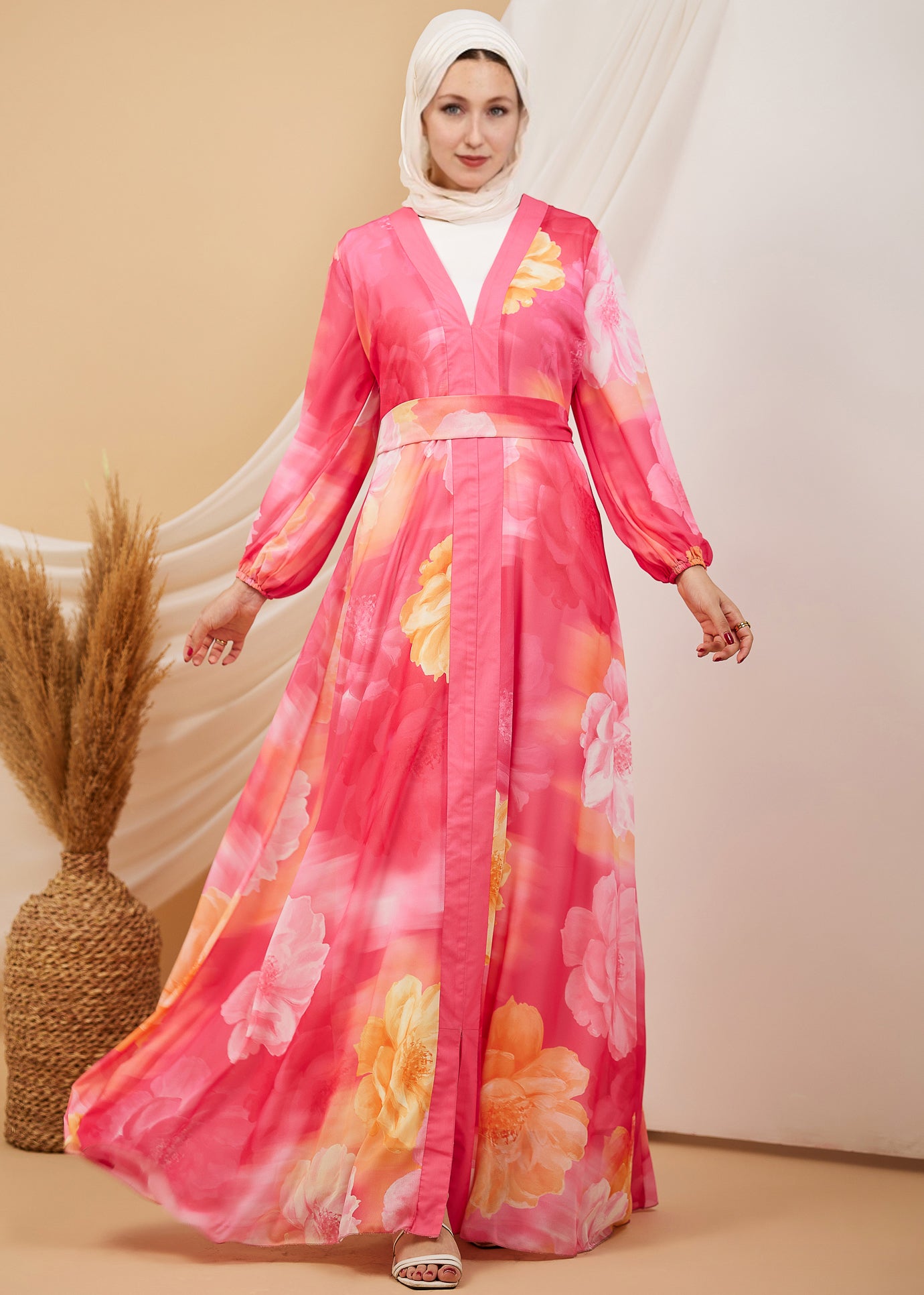 Front view of a model in a coral floral chiffon maxi dress with flared sleeves