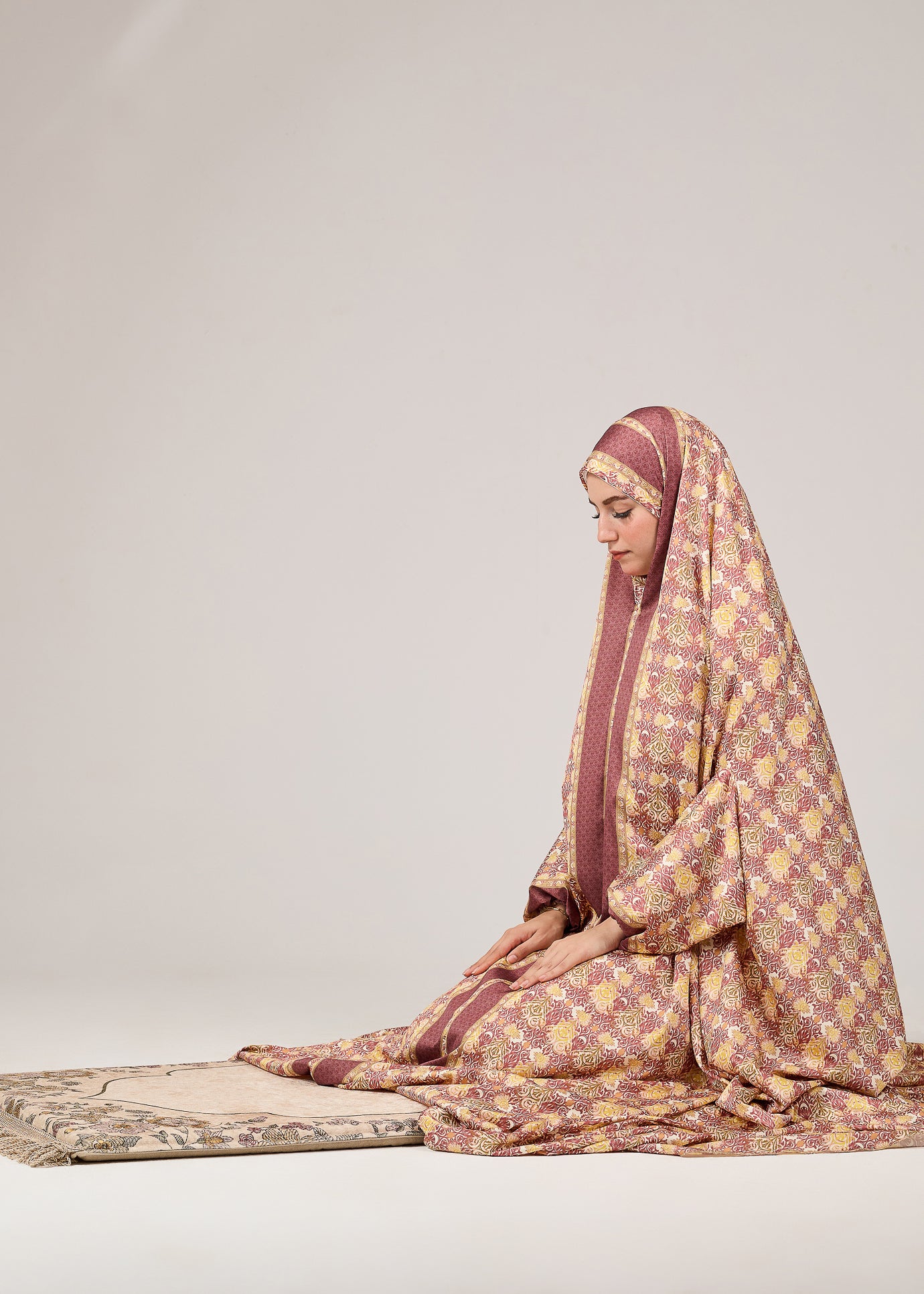 Profile view of model in satin floral prayer gown