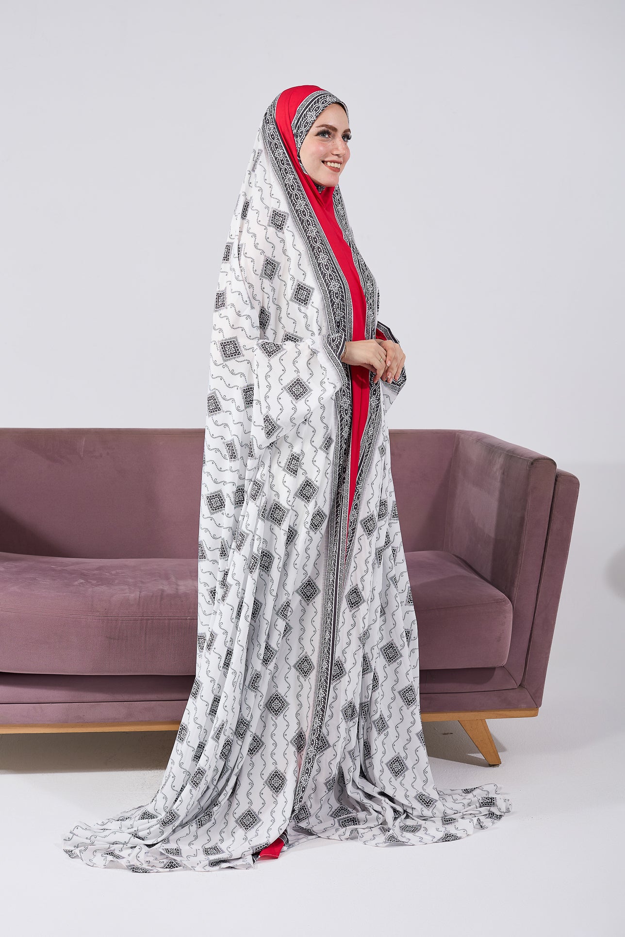 Side view of woman in black and white satin prayer gown with ornate design