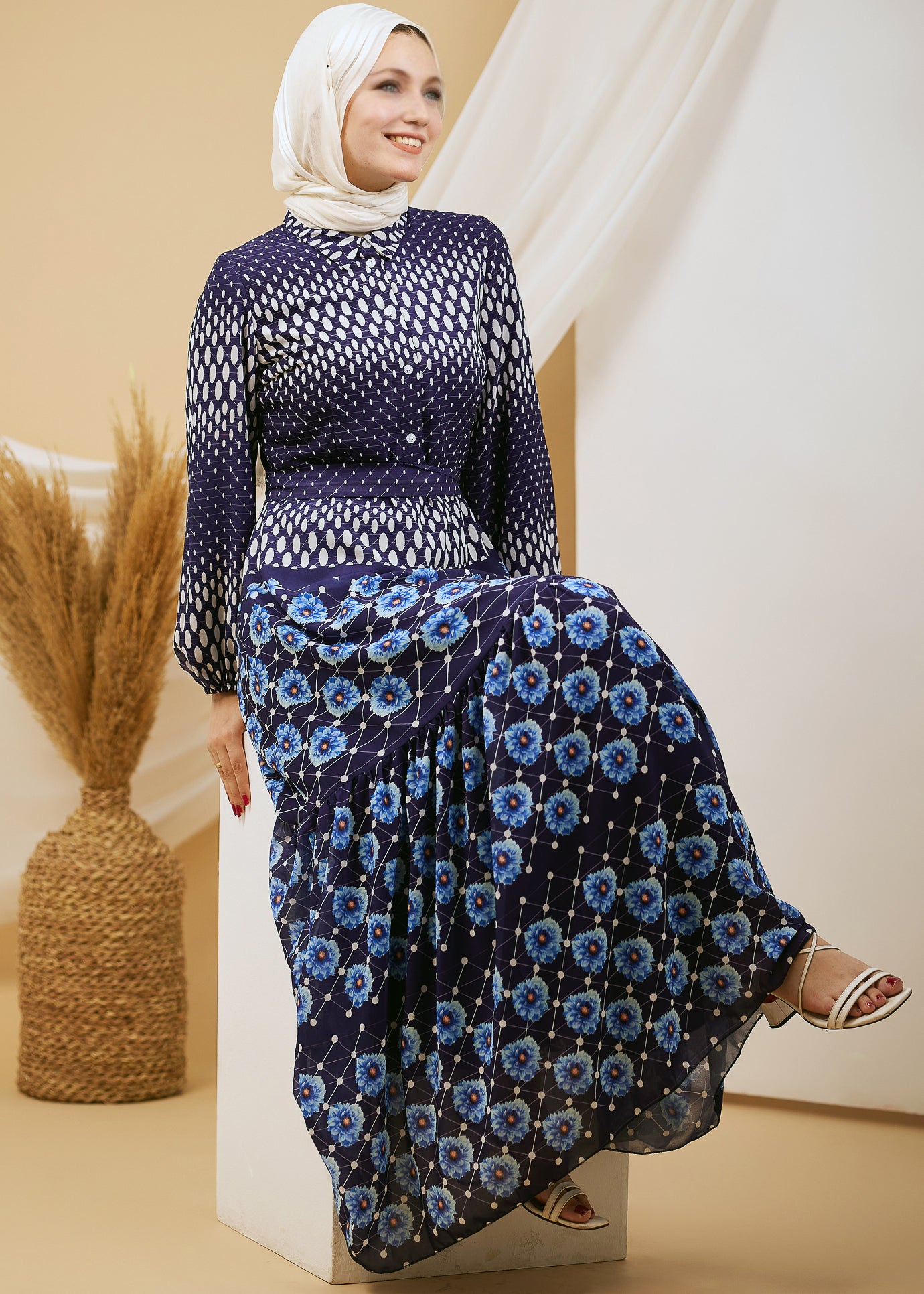 Model seated, showcasing the elegance of the navy floral chiffon maxi dress