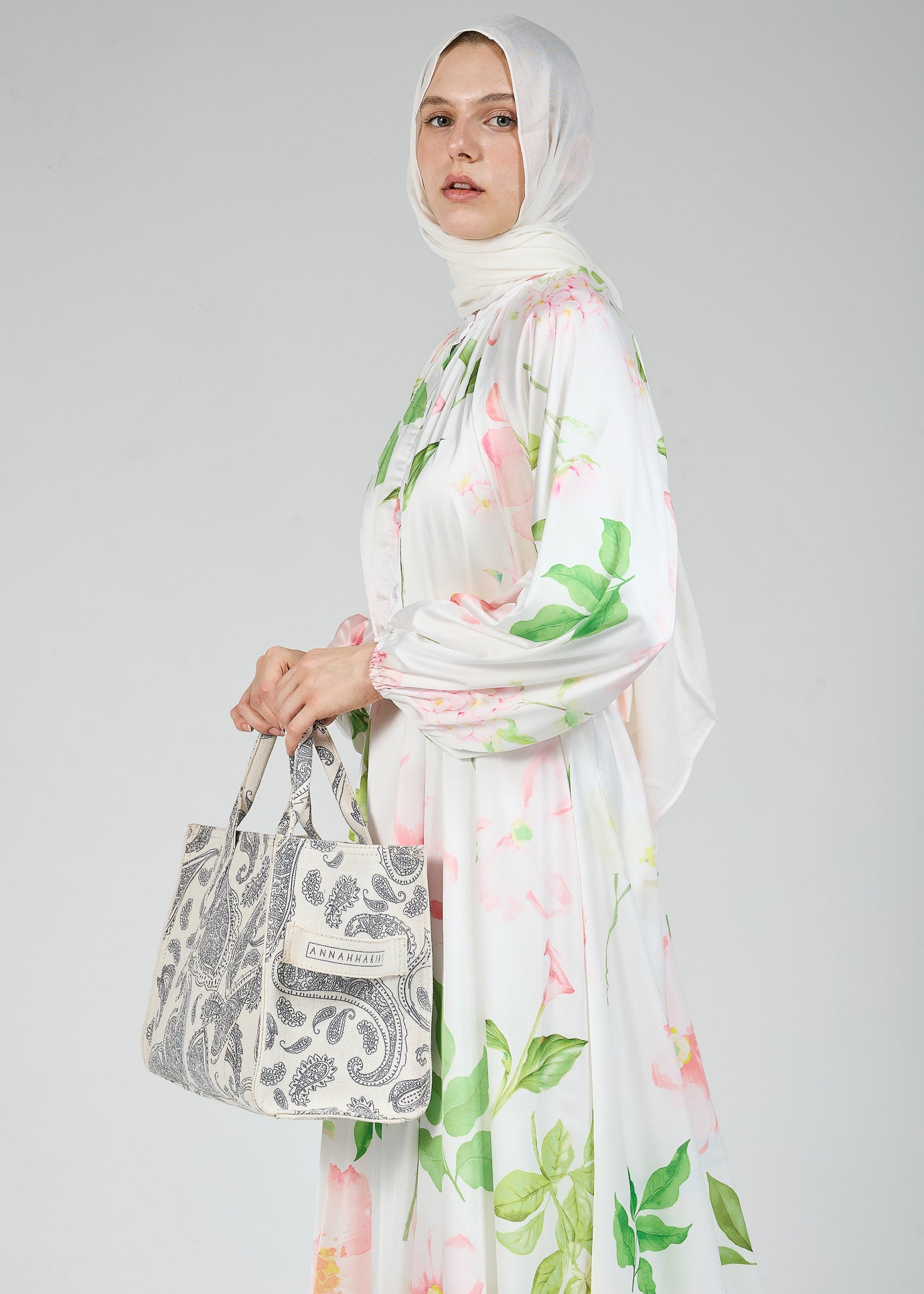 A graceful white floral satin dress with a modest, long-sleeve design
