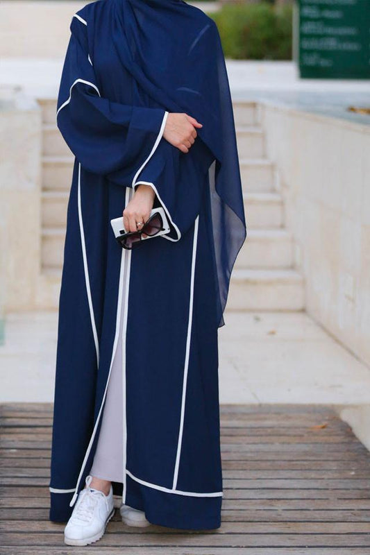 Front view of dark blue abaya with white trim