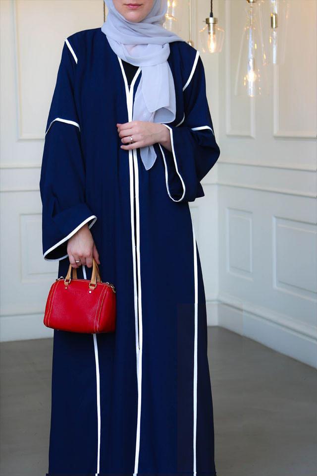 Detail of white trimming on dark blue abaya